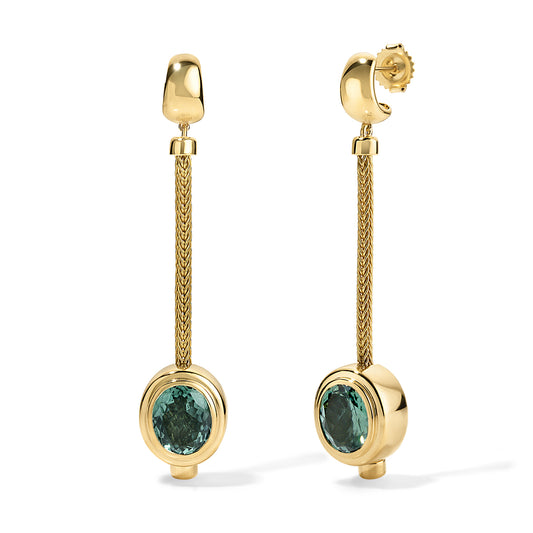 Gold earrings with green gemstones on a white background