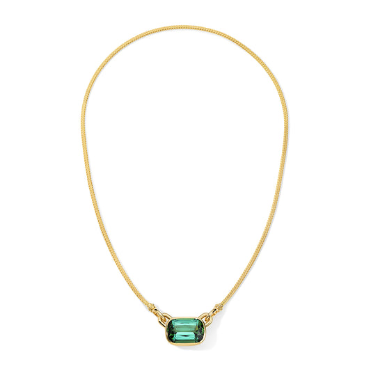 Gold necklace with a green gemstone on a white background